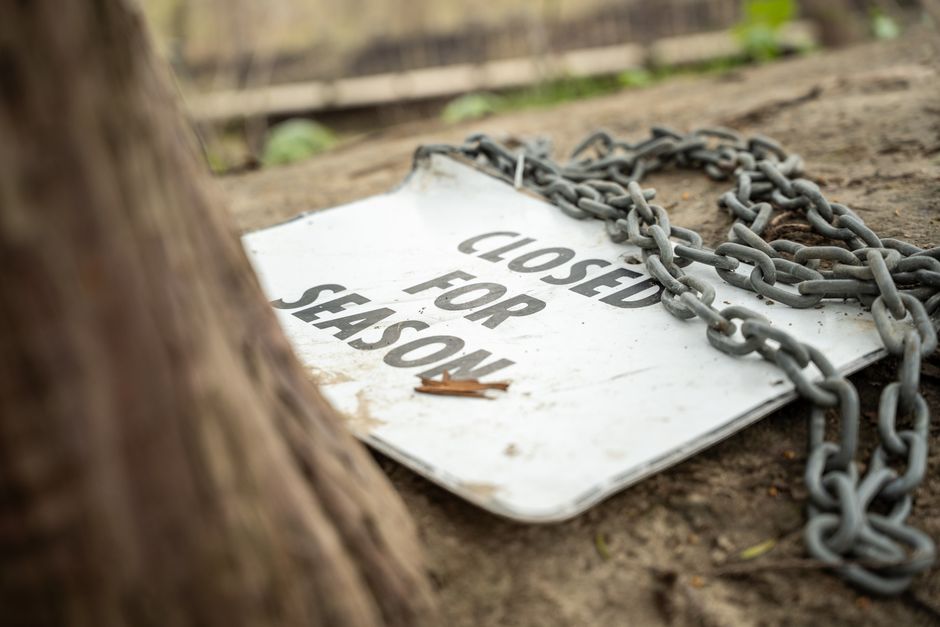 Close-up view of a metal bottle cap embedded in gravel and small stones outdoors, with the engraved message reading 'What you're made of matters.' The cap appears weathered and partially covered with